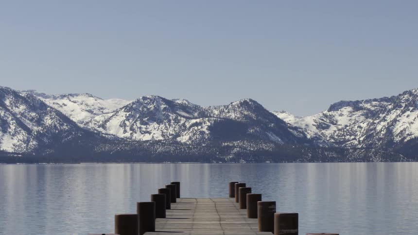 A dock extends into a mountain lake