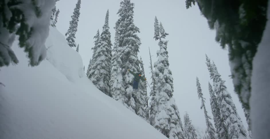 A skier jumps and does a 360 into powder