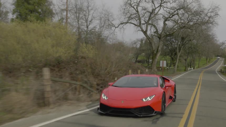 A sports car drives on a rural road