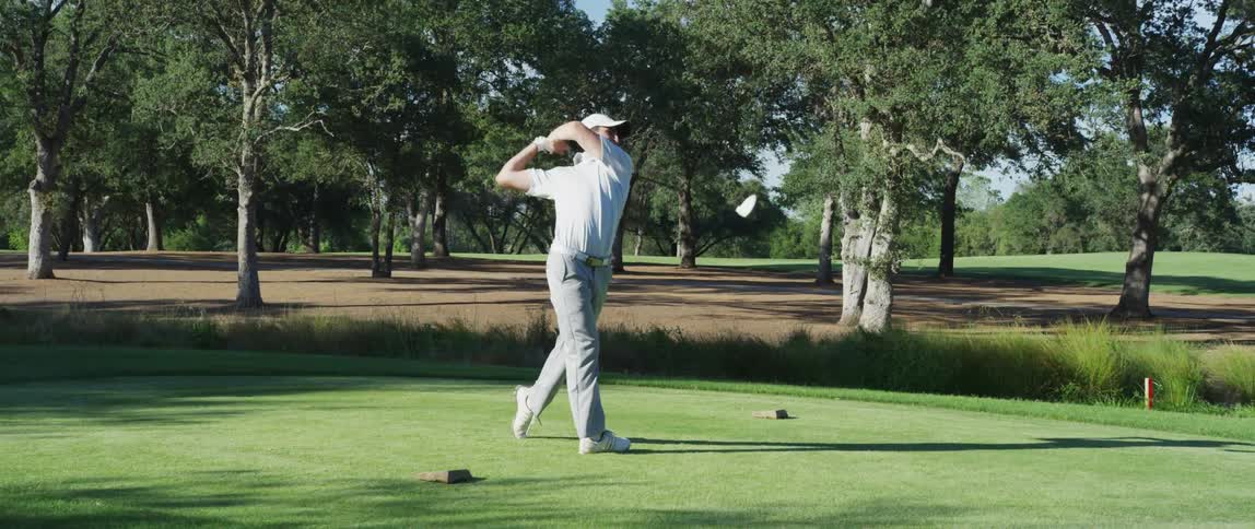 A young man taking an golf shot