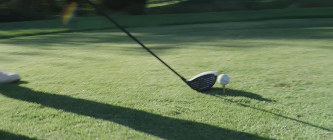 A golfer winds up to hit a ball