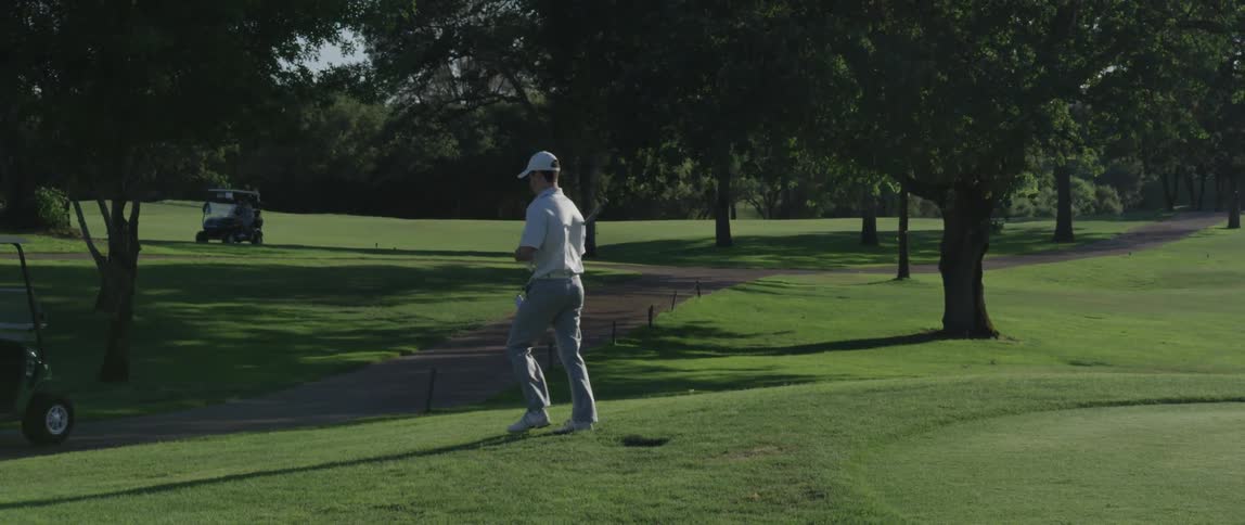 Man with golf club walking on golf course