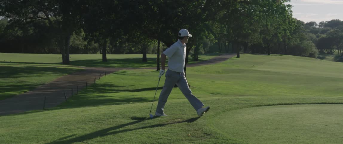 A golfer approaches the green