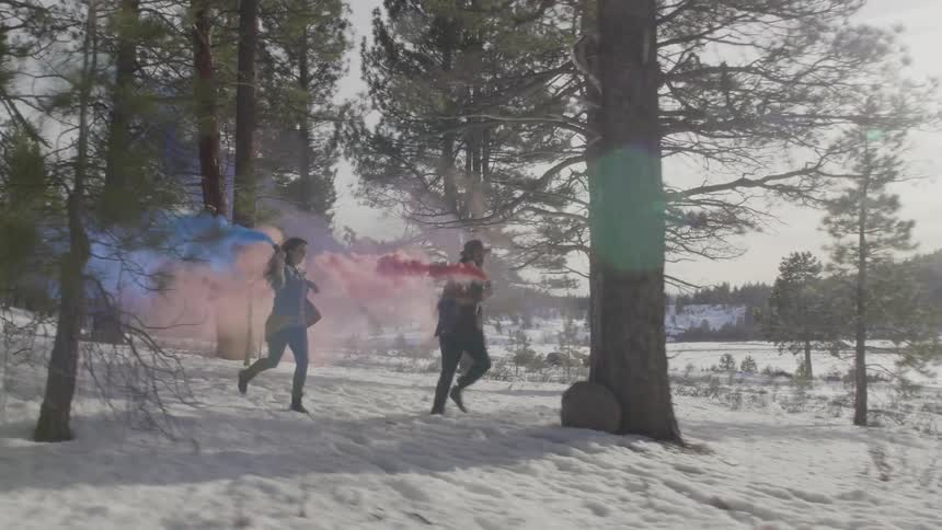 People running through a forest carrying smoke canisters