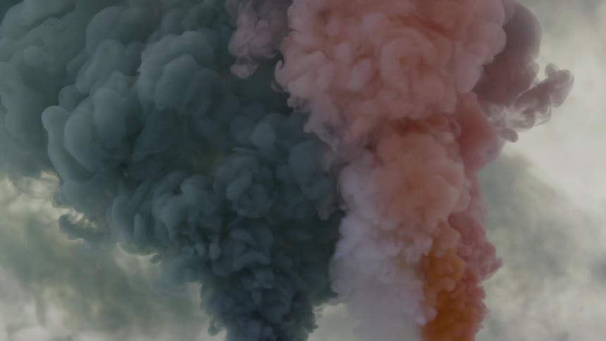 Blue and red smoke is rising fast into the sky
