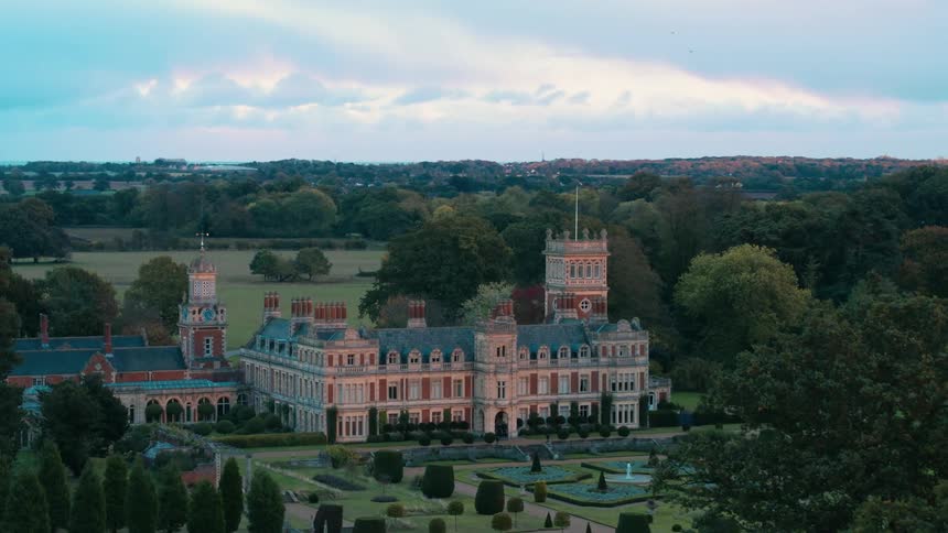 A church on a very well manicured lawn with a skyline in the background