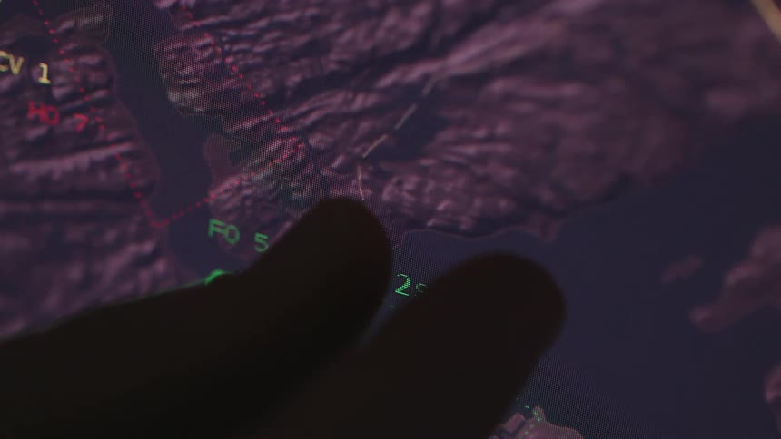 A person using their fingers to operate a touch screen displaying outdoor terrain