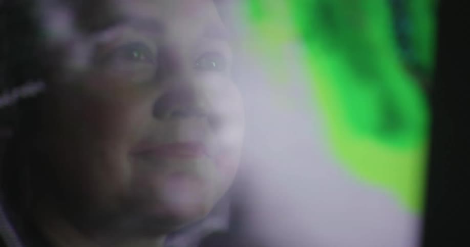 A woman is looking at weather patterns on the monitor