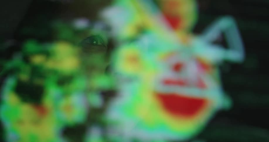 A white woman watches a monitor with weather radar images on it