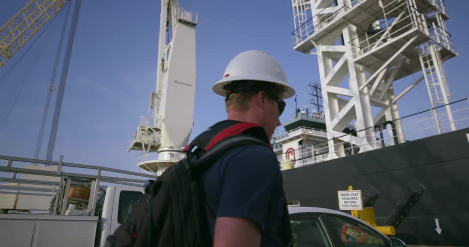 A man walks towards a cargo ship