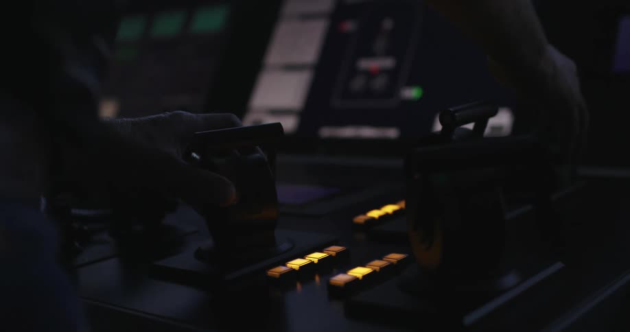 A person is leaning over the levers on the console