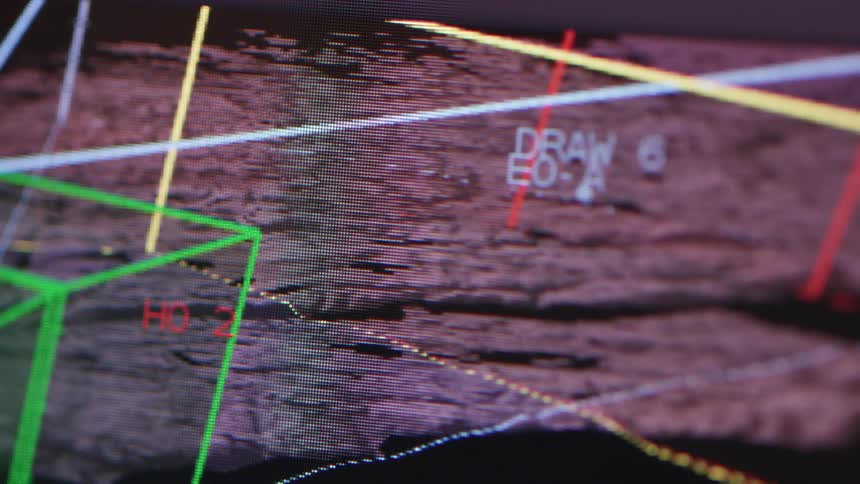 Finger points to graphic software on a monitor