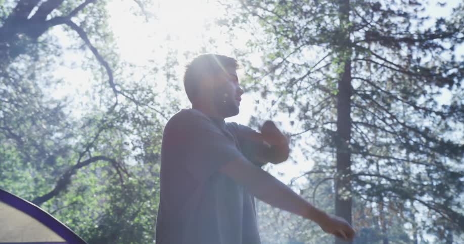 A man stretches after he climbs out of a tent