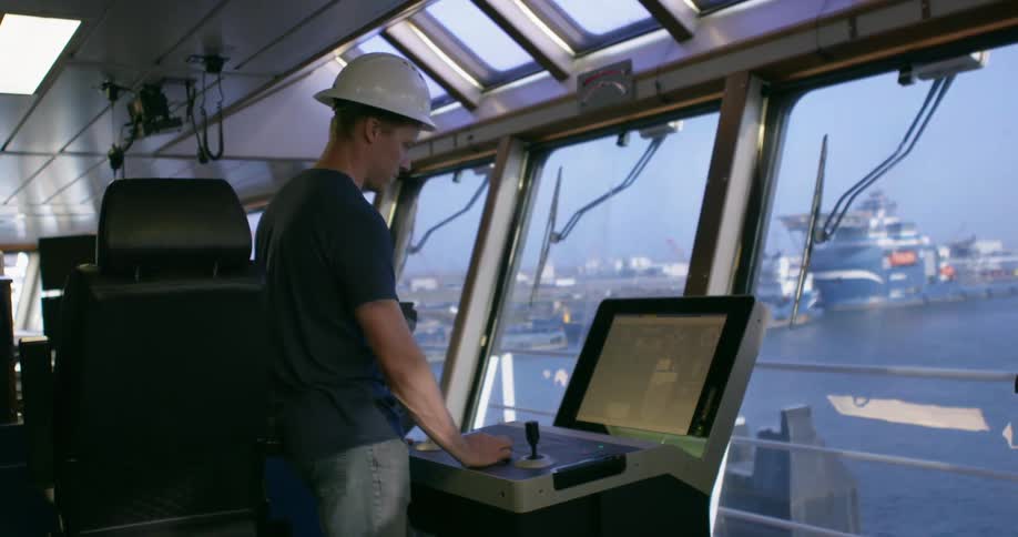 A man working on a boat looks at a monitor