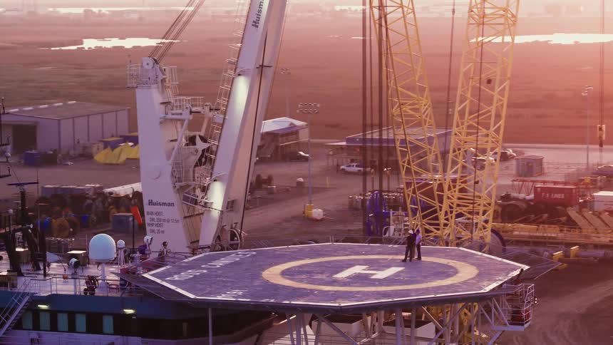 Aerial view of a helipad at the top of a ship at sunset