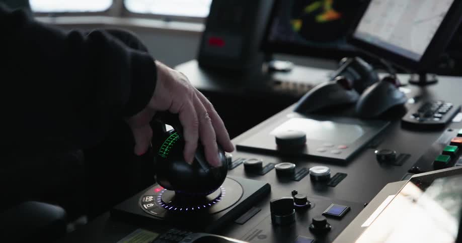 An air traffic controller turns a knob while monitoring radar on a computer monitor