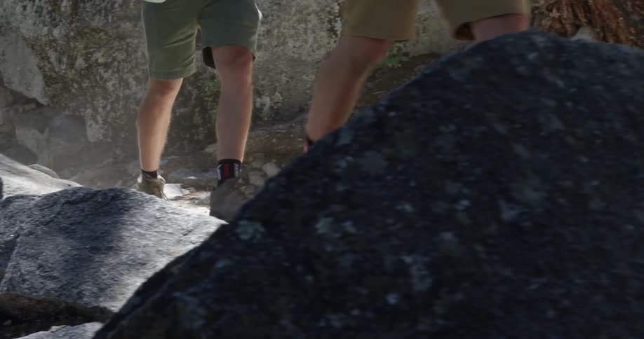 A group of men walk on a rocky trail