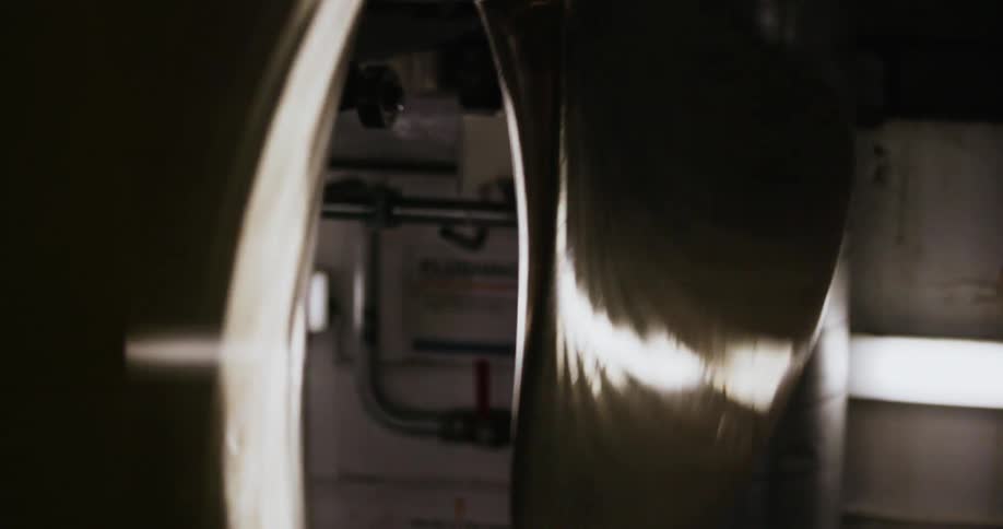 The steel blades of a round fan going round and round reflecting light