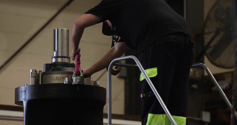 A man places parts on some equipment