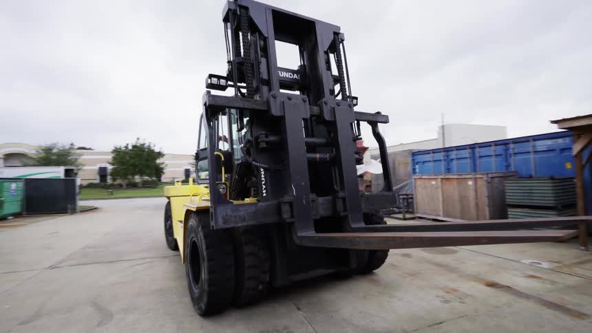 Forklift powered industrial truck driving reverse on a construction yard
