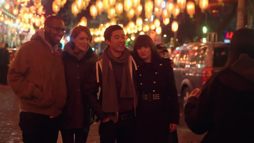 A group of people have a bystander take a picture of them on a smartphone