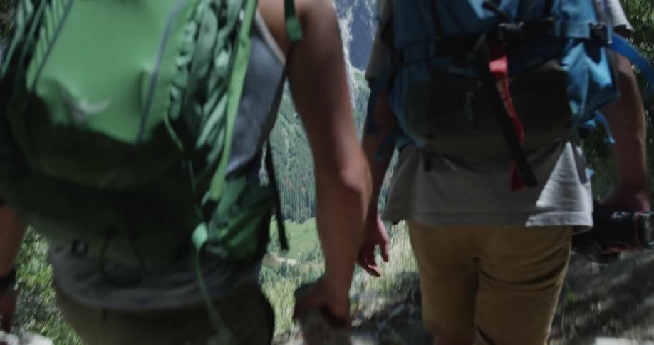 A group of men walk a mountain path