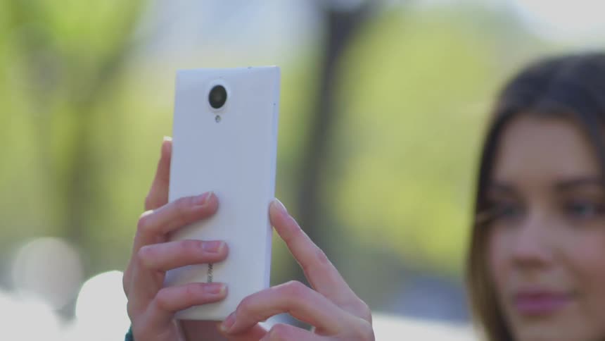 Woman takes a selfie in the public garden