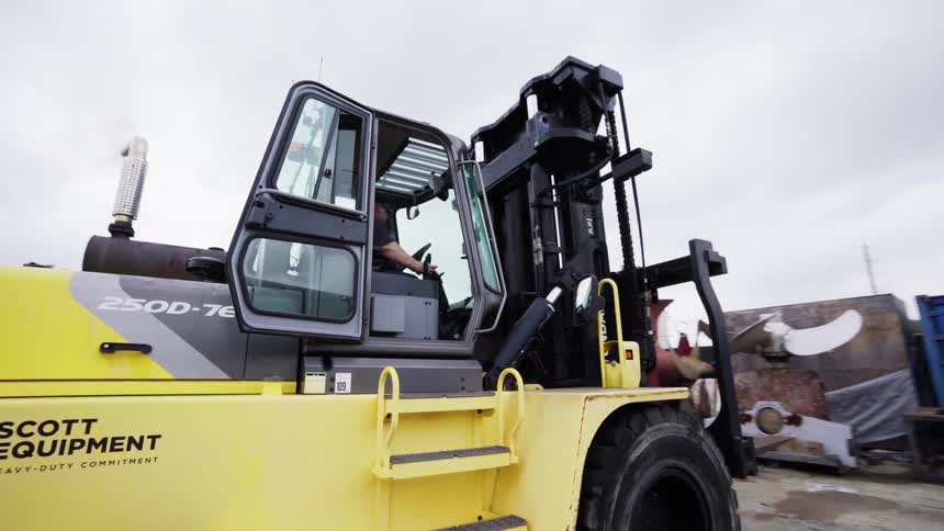 A man drives a vehicle towards shipping containers