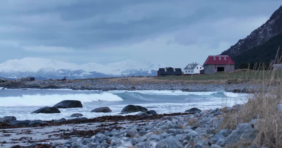 Waves roll into a rocky coast in a rural area