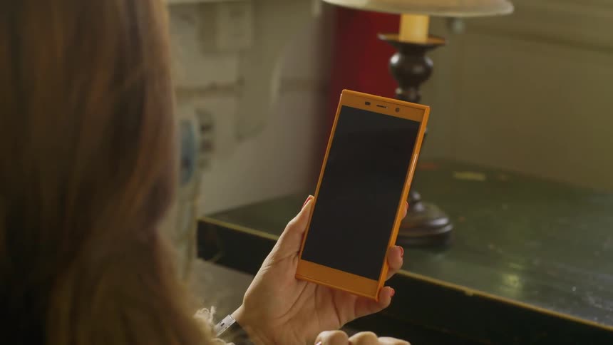 A white man touches and scrolls on a smartphone device