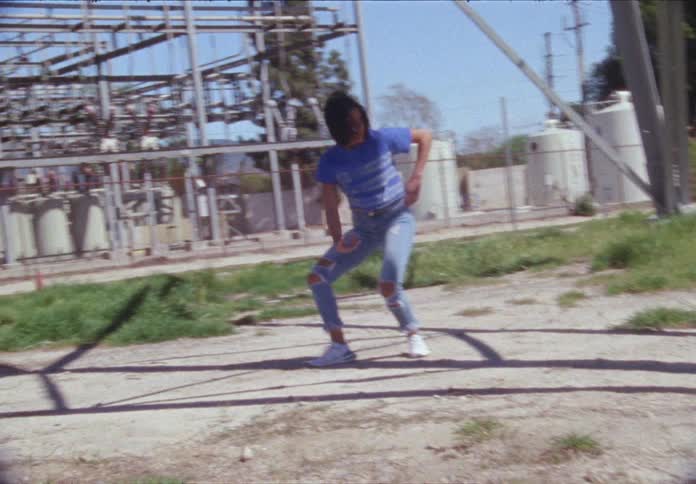 Woman dancing in front of transmission towers