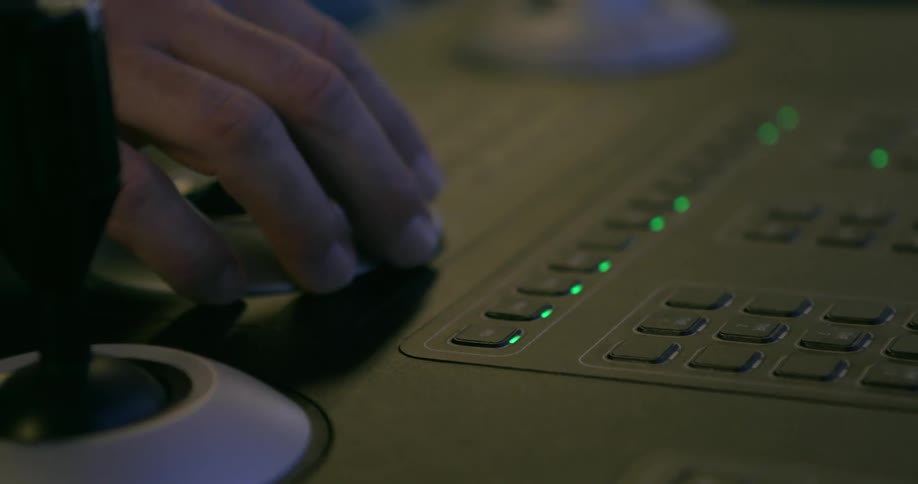 A man has his hand next to lighted keys on a keyboard
