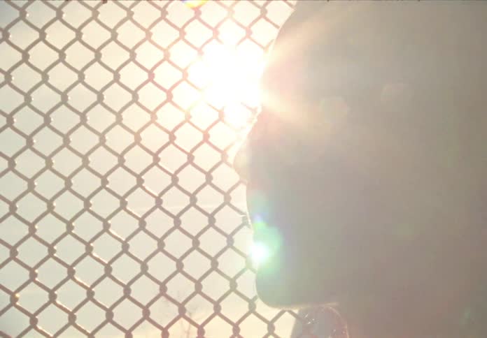 Woman stands in front of the wire fence