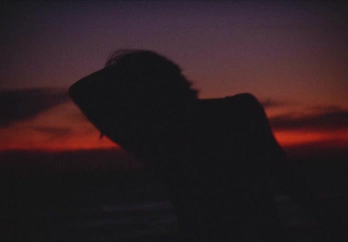 A woman dances wildly outdoors
