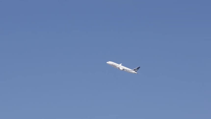 Passenger airplane taking off against blue skies