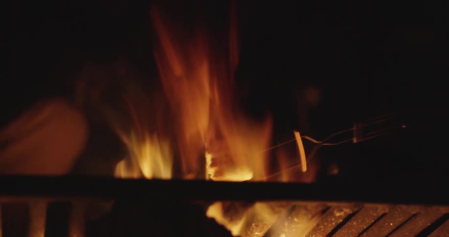 A marshmallow roasts over an open flame