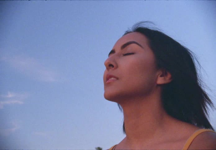 A hispanic teenager breathes deeply while outdoors