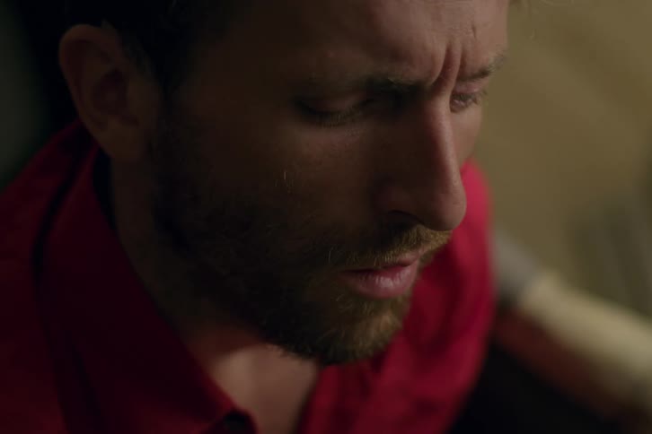 A white man looks worried as he talks to himself