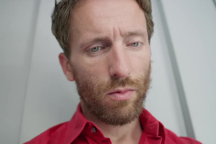 A man looks ahead like he is concentrating and then swallows hard