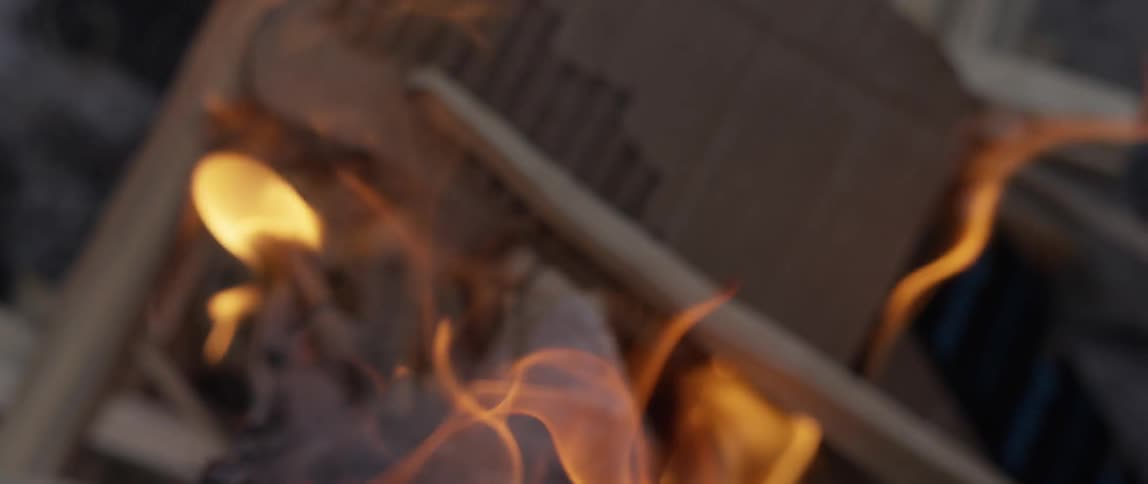 Cardboard and sticks burning in a campfire