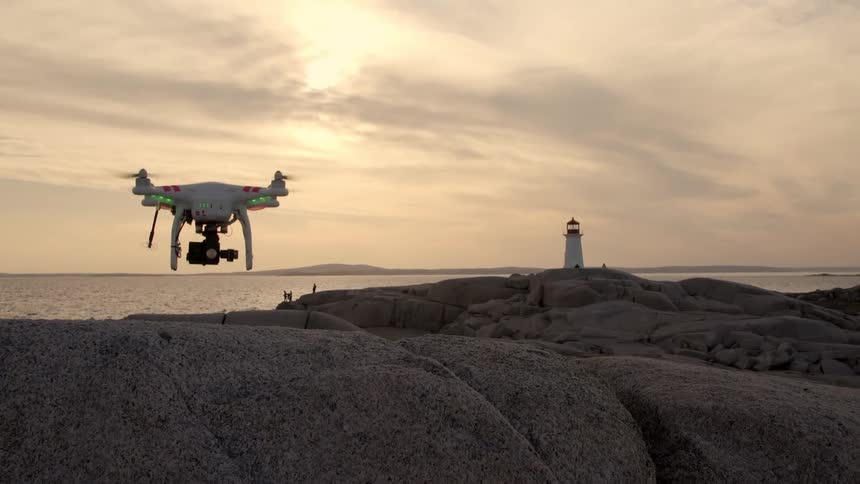 Drone taking off a cliff on the coast at sunrise