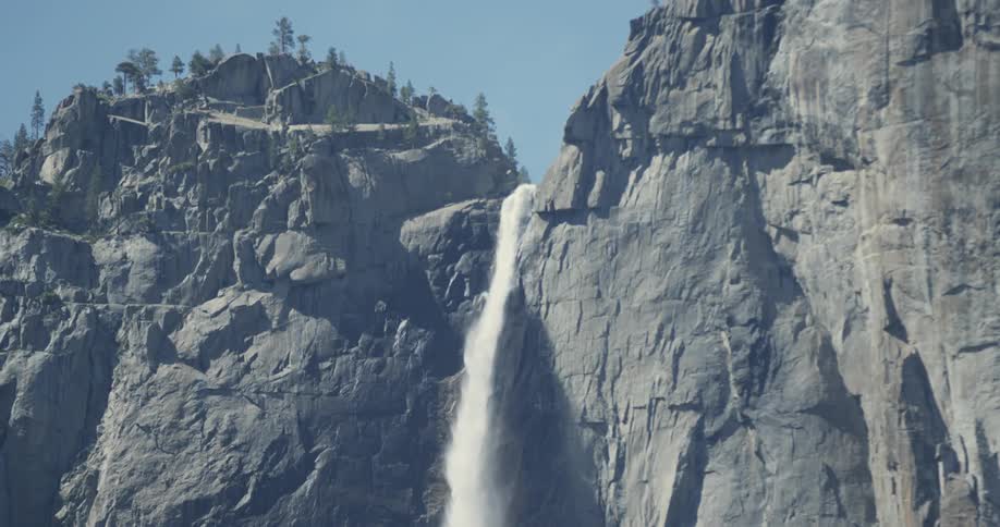 A waterfall cascades over a tall cliff