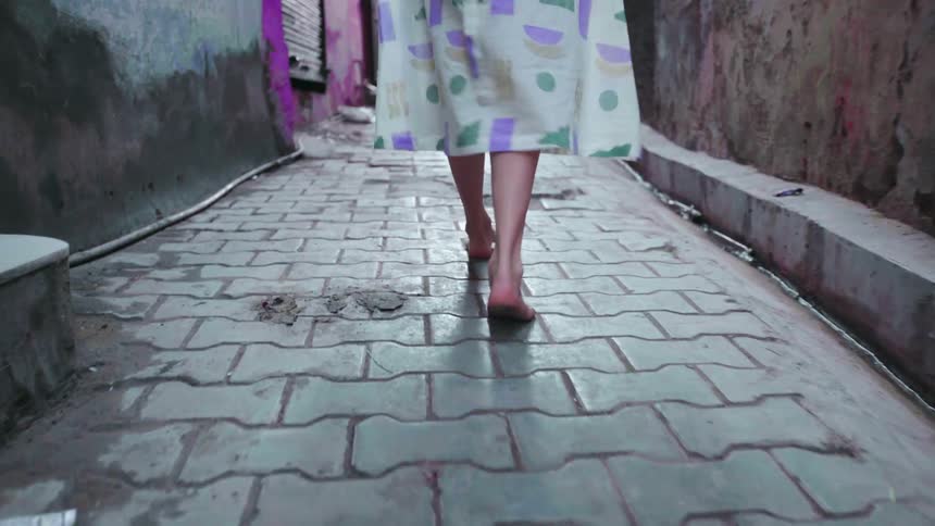 Woman walks barefoot in the alley