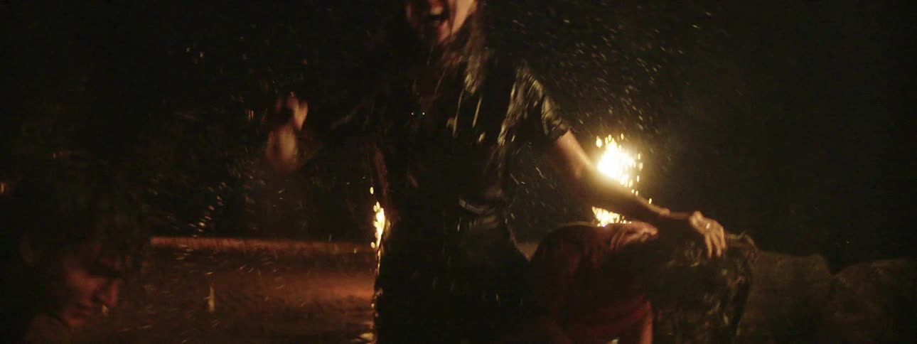 Three friends have a water fight as flares go off in the background