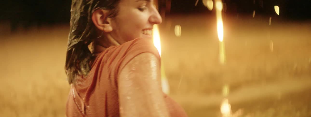 Friends playing on a beach at night surrounded by fireworks