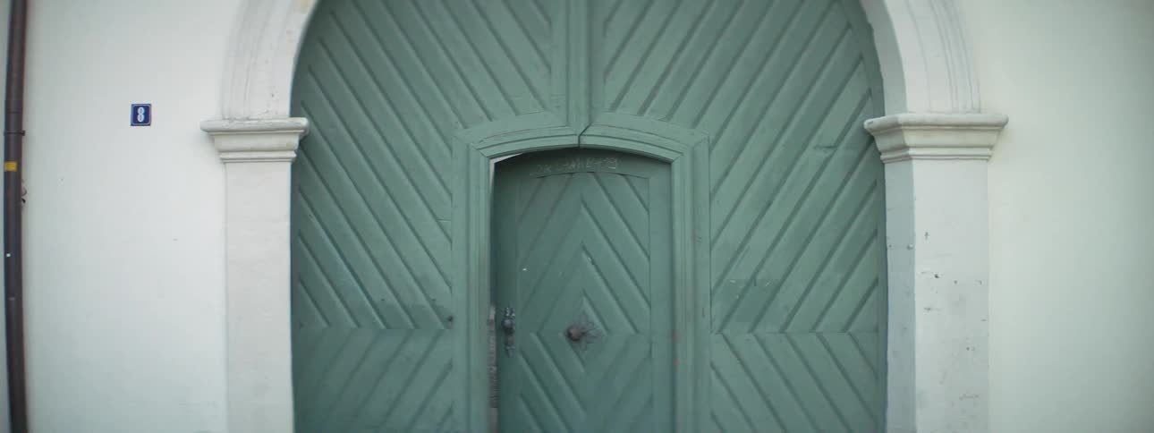 An exterior door to a home slowly opens