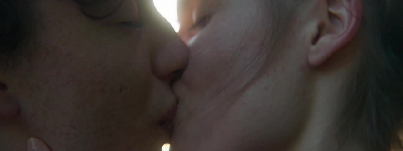 Man and woman kiss and touch each other at sunset