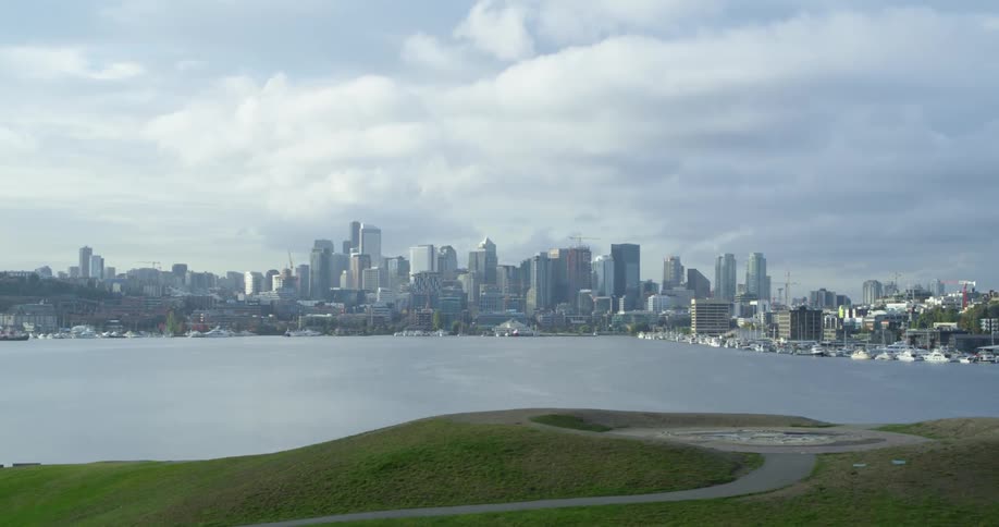 Lake sits between a city and hills with a trail