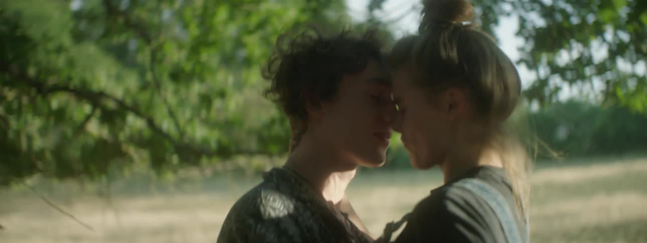 Two teenagers kissing outside