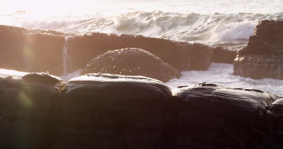 Ocean waves crashing into a large rock formation